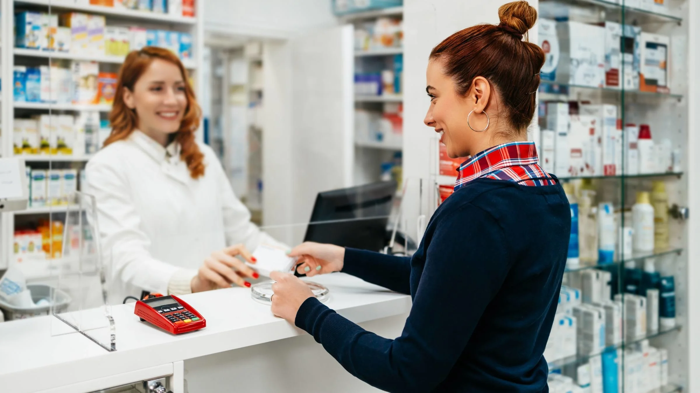 A patient handing a card to a pharmacist.