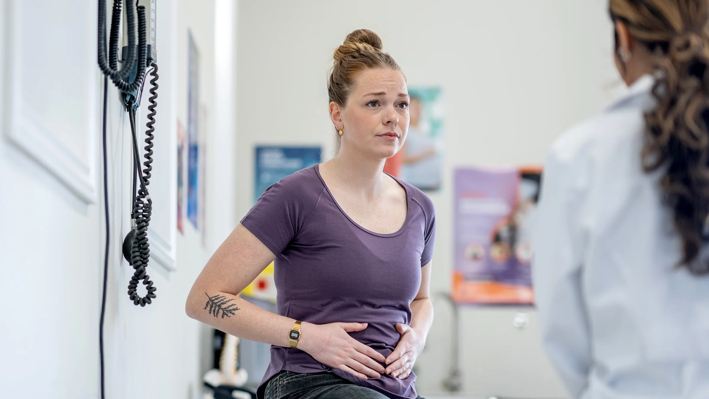 Woman with abdominal pain at a medical appointment.