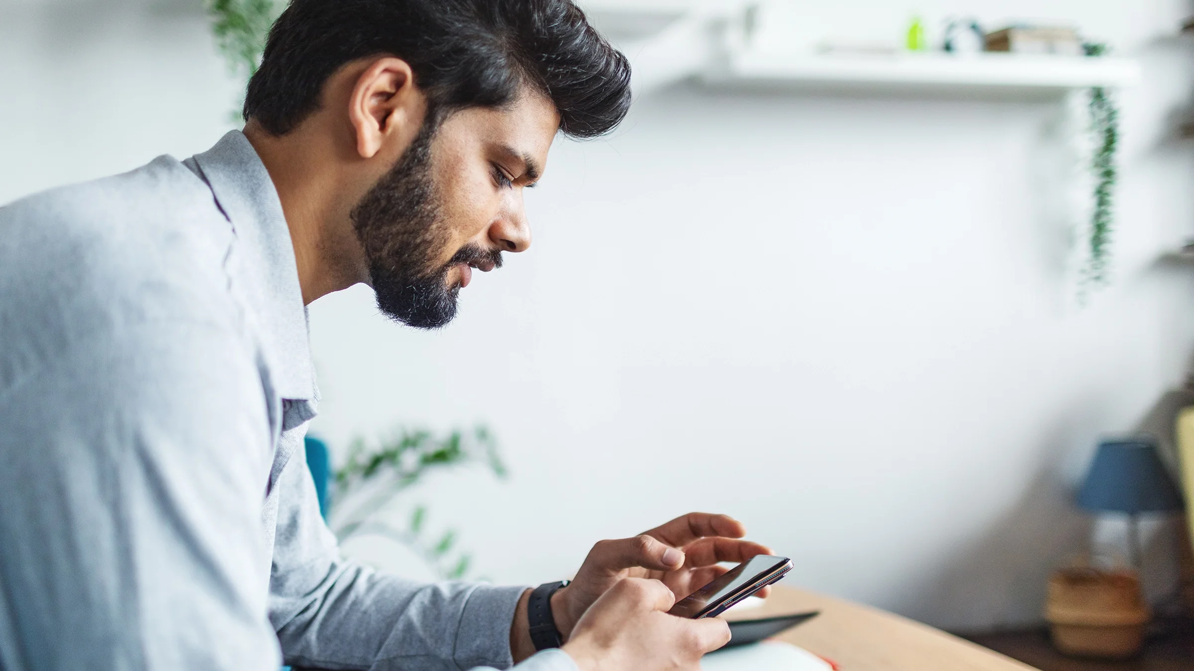 A man uses a mobile phone at home.