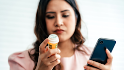 A woman looks up information about her medication on her phone.
rachasuk/iStock via Getty Images Plus    
