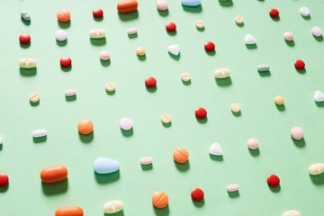 Rows of various pills on a light green background. They are lined up on a slight diagonal with the perspective shifted so it looks like the pills are fading off into the distance.