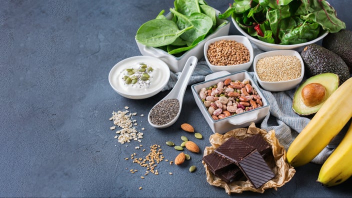 Assorted magnesium rich foods on a black and gray textured background.