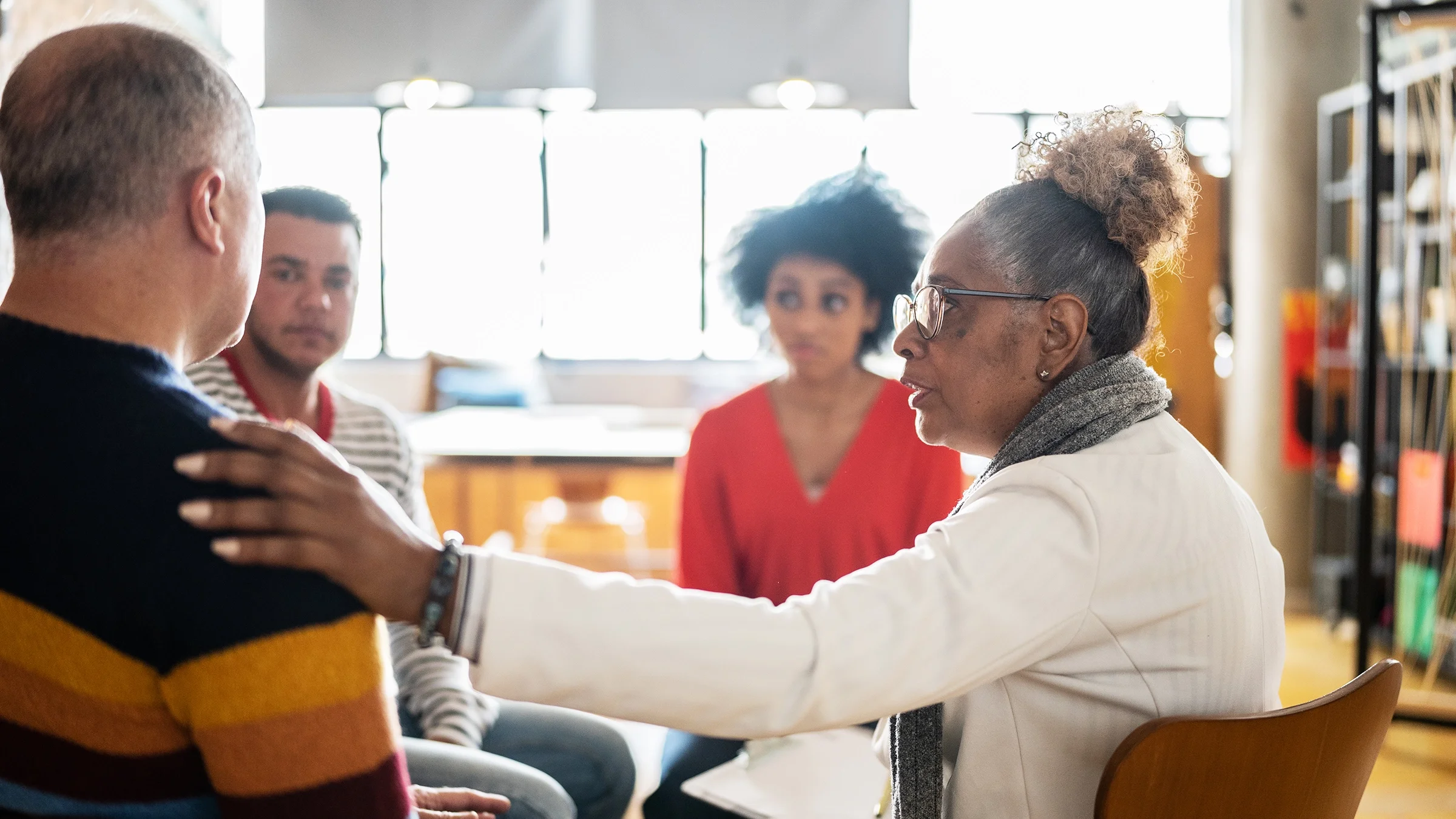 Woman comforting a man during group therapy