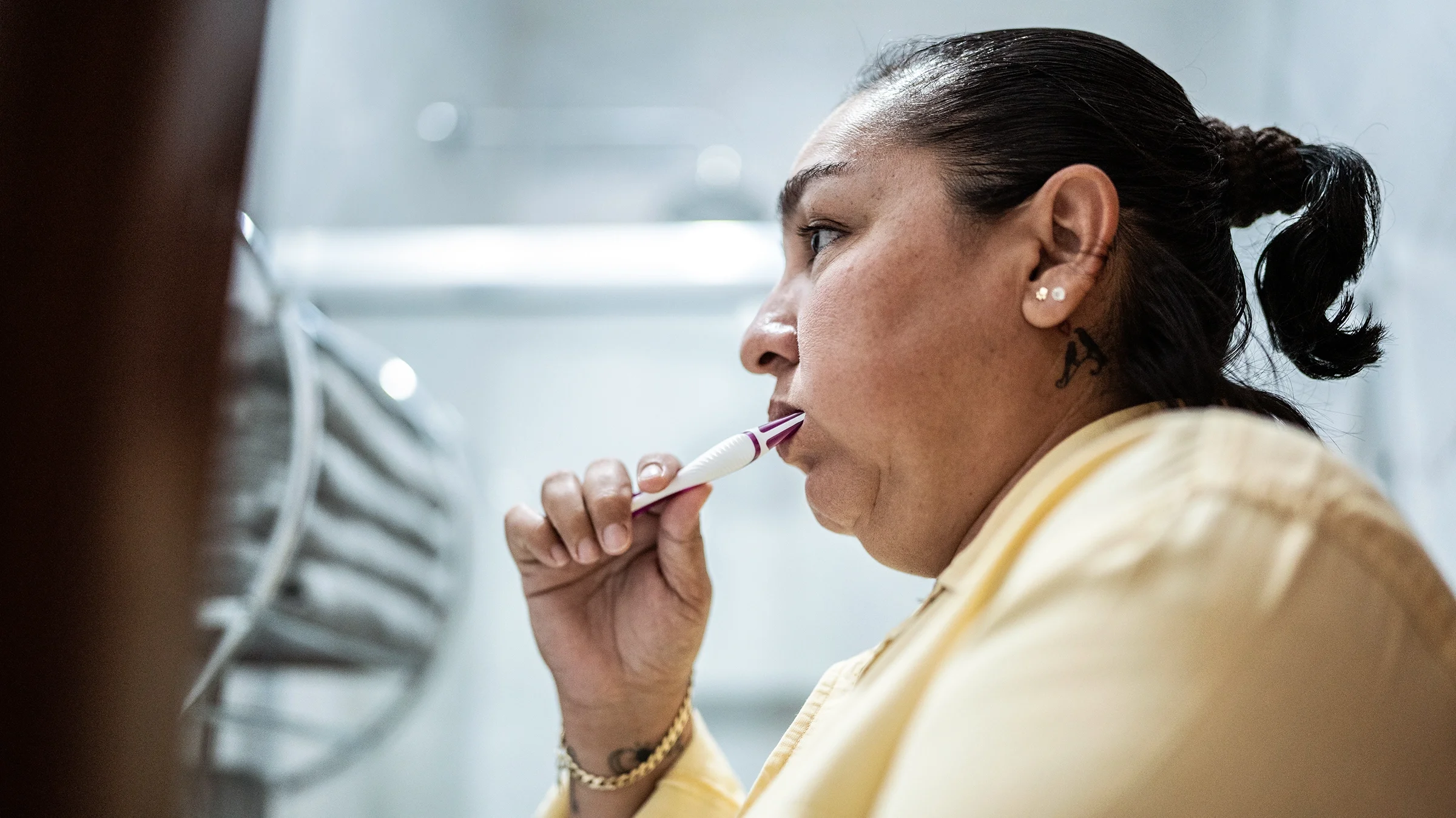 A person is brushing their teeth in a bathroom.