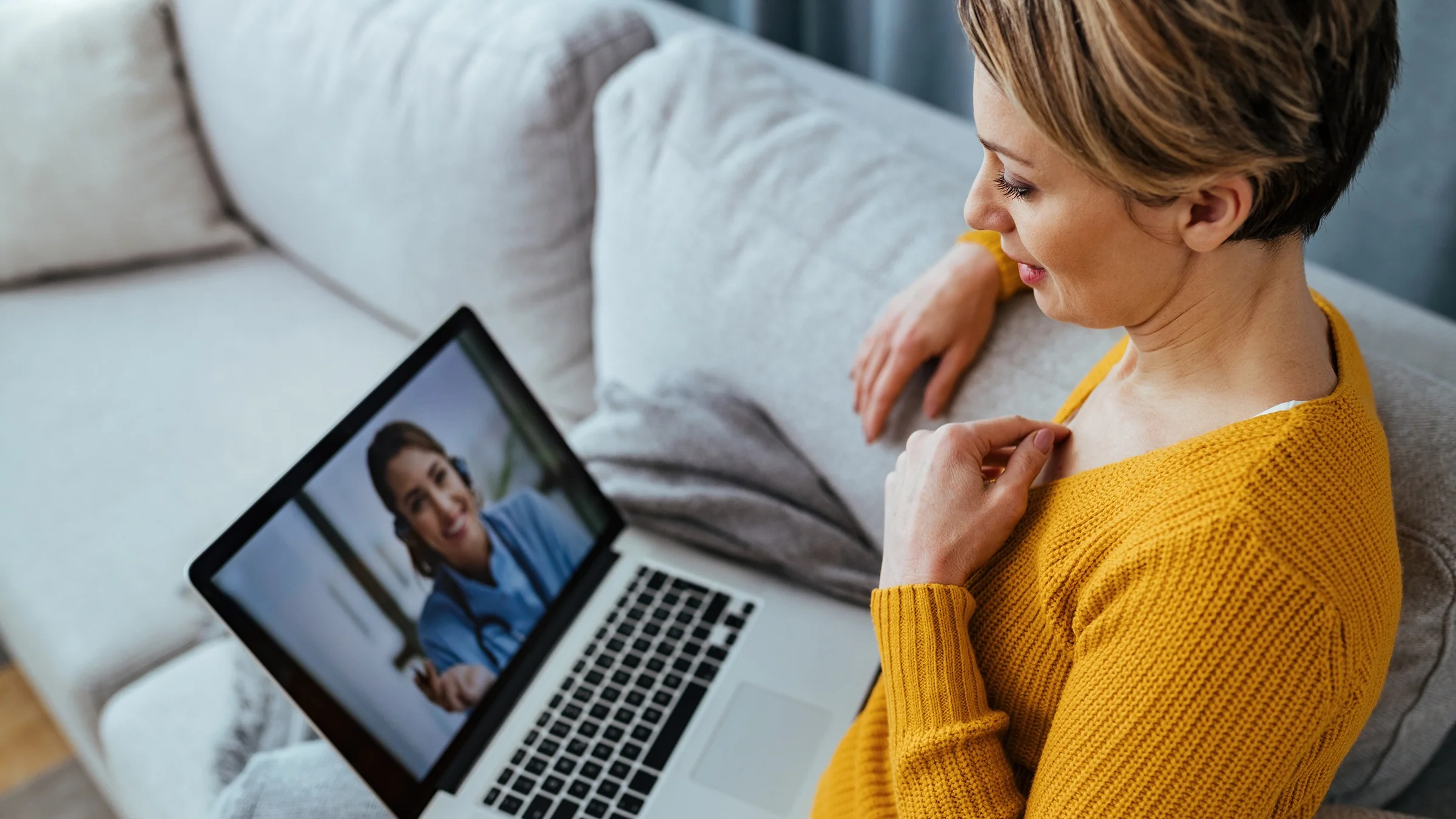 Woman having a telehealth call with her doctor from her home.
