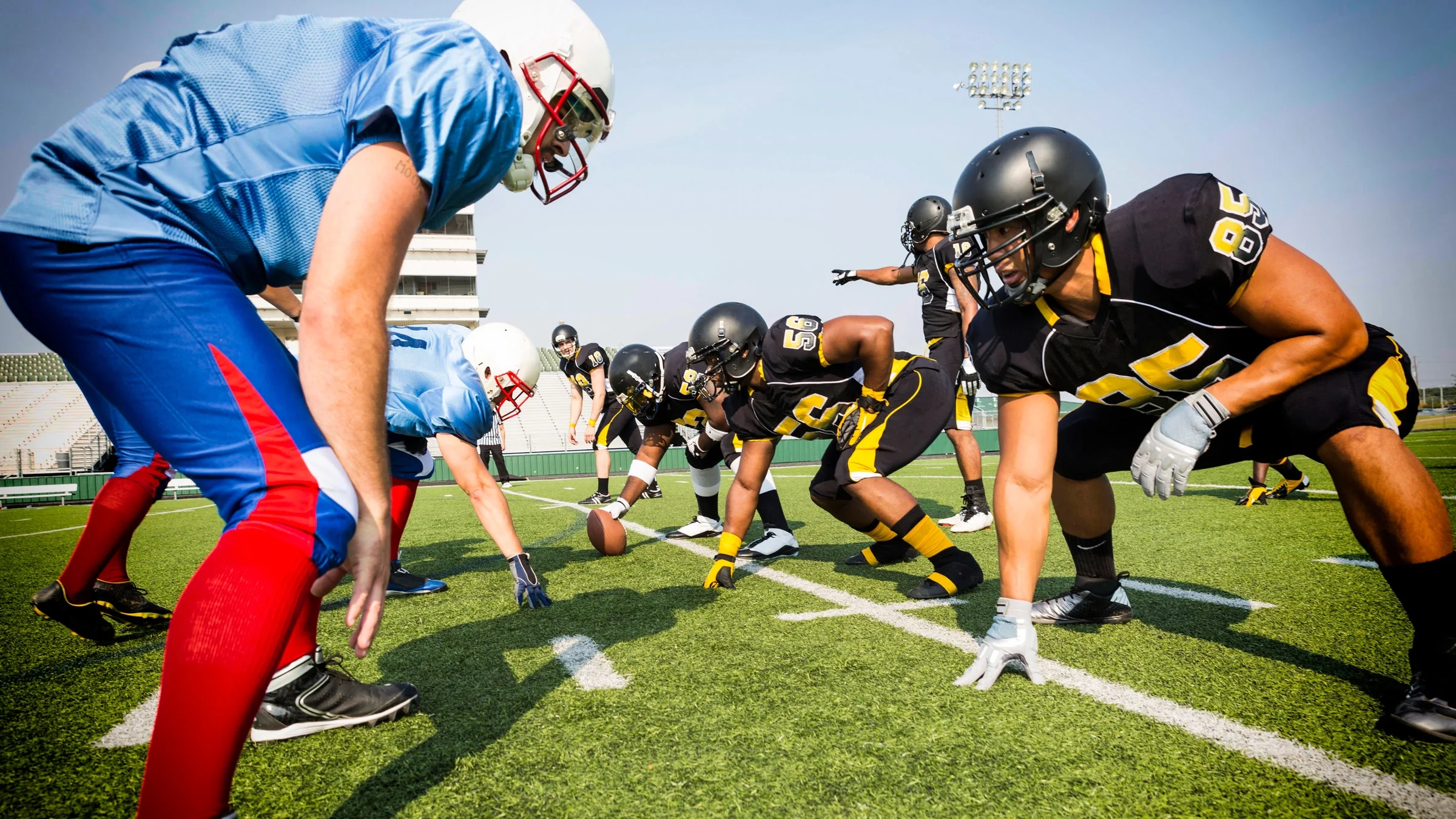 Two football teams lining up and facing off.