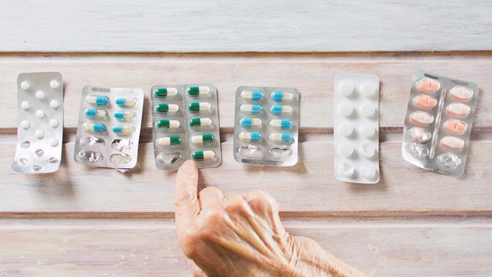 A hand pointing at a blister pack from a row of blister packs.