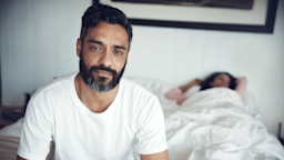 Man upset in bed with woman.
laflor/iStock via Getty Images Plus
