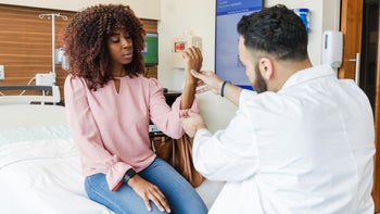 Autoimmune: doctor examining womans wrist 1646995687