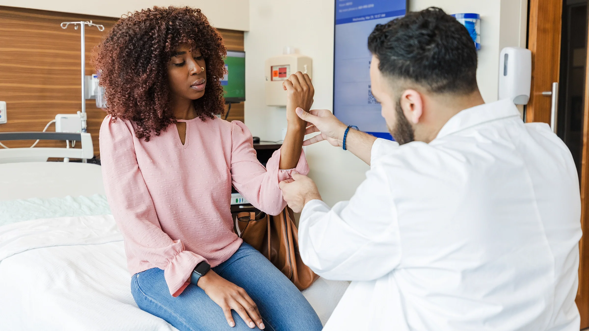 A doctor examines a woman's wrist.