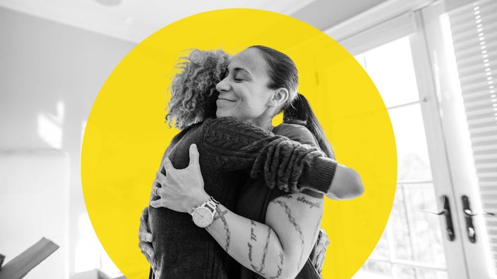 Caption: Mother hugging her daughter in the living room. She has her eyes closed and looks happy and content.