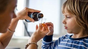 medication-education: mother giving child cough medicine 1218757821