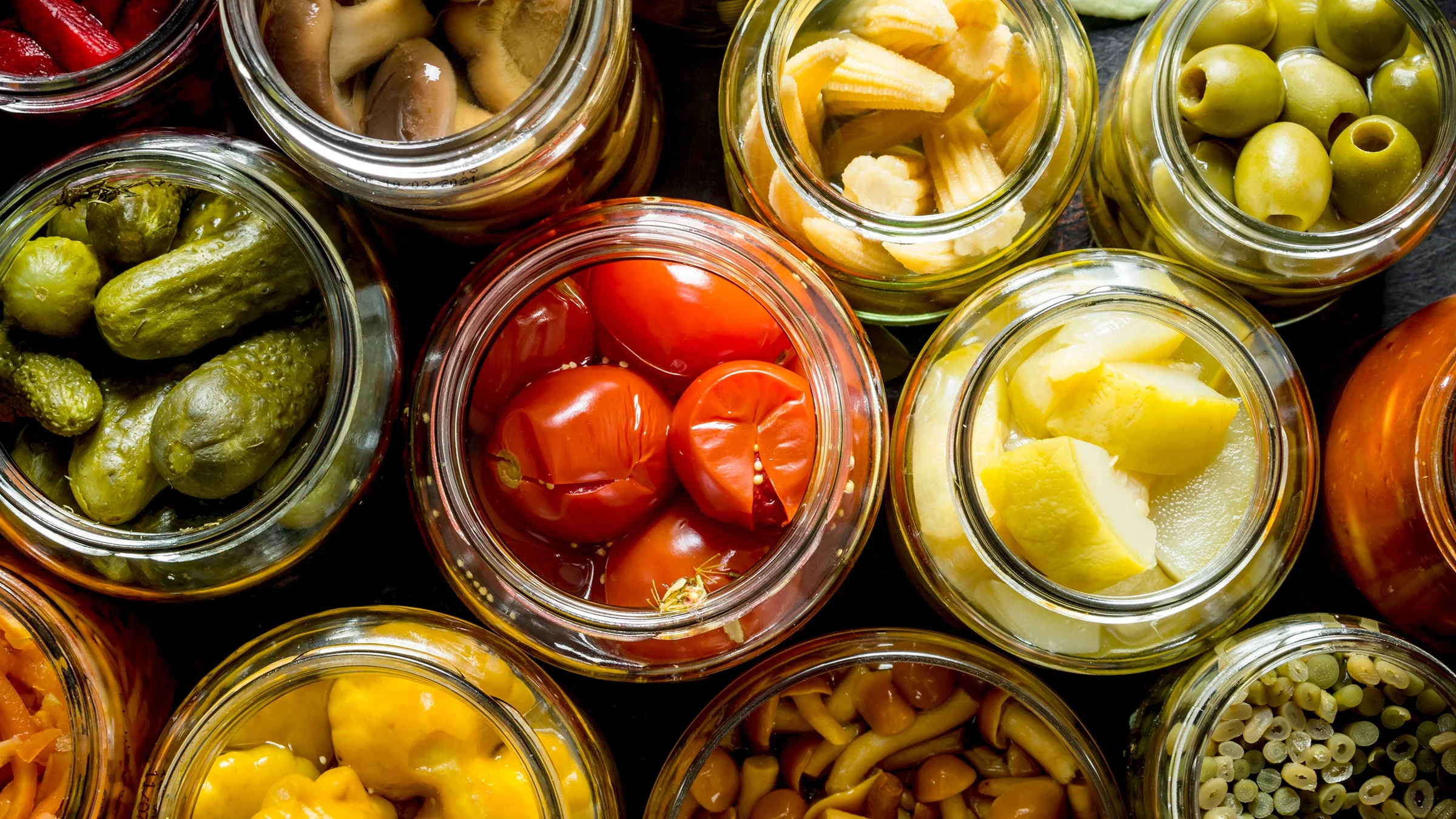 Overhead view of preserved vegetables in glass jars