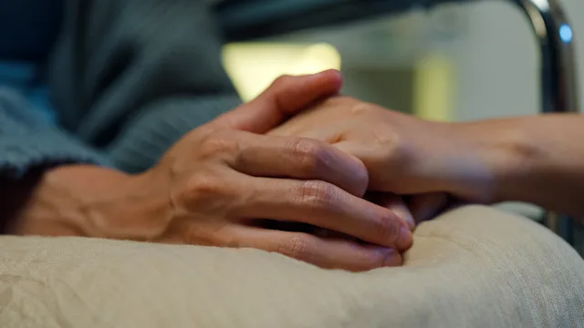 end-of-life: closeup hands gripping together 1821643708