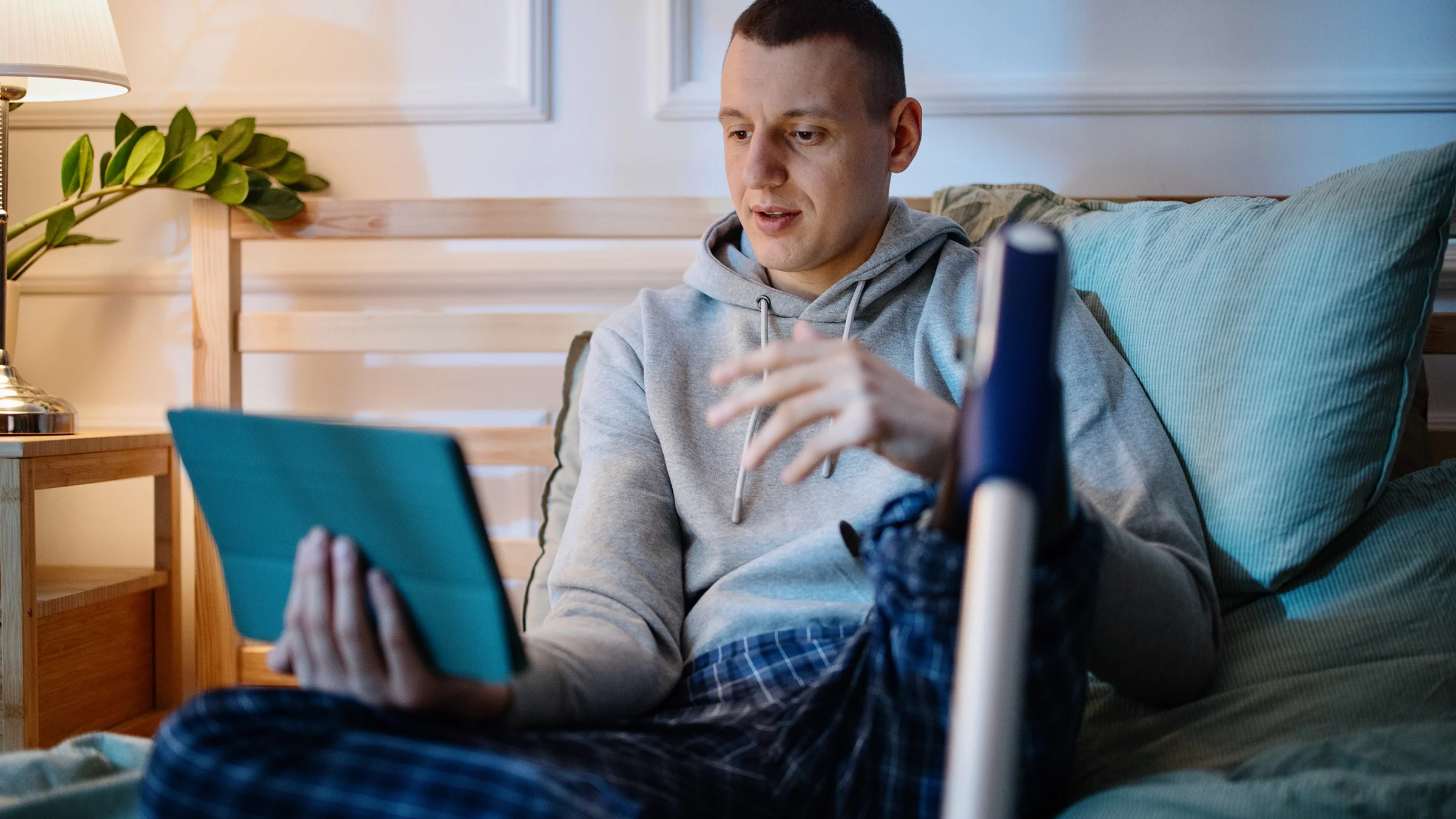 A young man with a prosthetic leg is having an online mental health session.