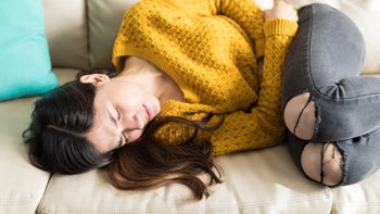 GERD: Acid rebound: woman couch stomach cramps-1096060490
