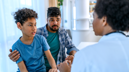A father and son talk to a healthcare professional.
bluecinema/E+ via Getty Images