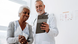 A doctor meets with a senior patient while using a digital tablet.
andreswd/E+ via Getty Images