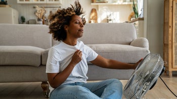 Health: Menopause: woman cooling down with a fan 1480852667