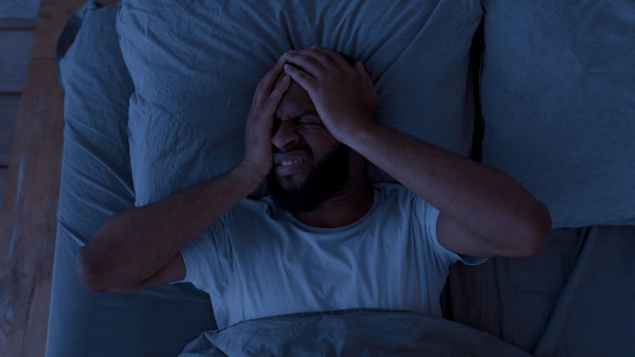 A man appears to be having trouble sleeping at night.