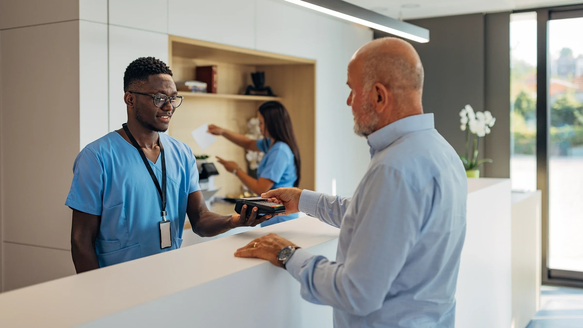 A customer taps his card to pay for medical services.
Kosamtu/E+ via Getty Images