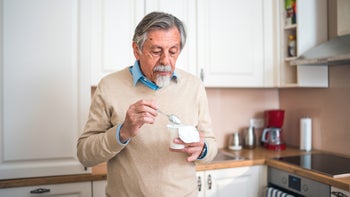 Diet Nutrition: man eating yogurt at home 1482190743