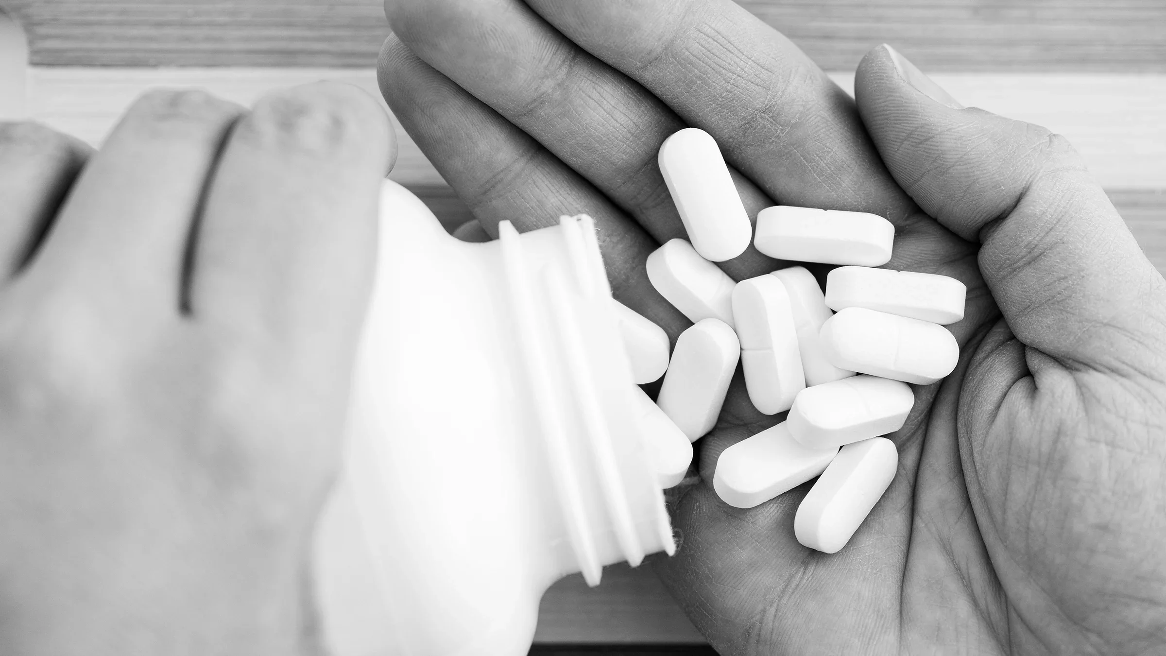 Black and white image of a person pouring magnesium supplements into their hand.
Professor25/iStock via Getty Images