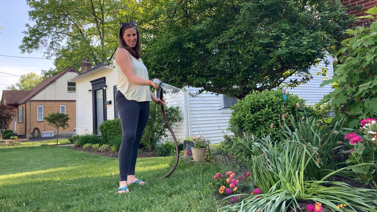 Judi Ketteler watering plants outside her home in Cincinnati.