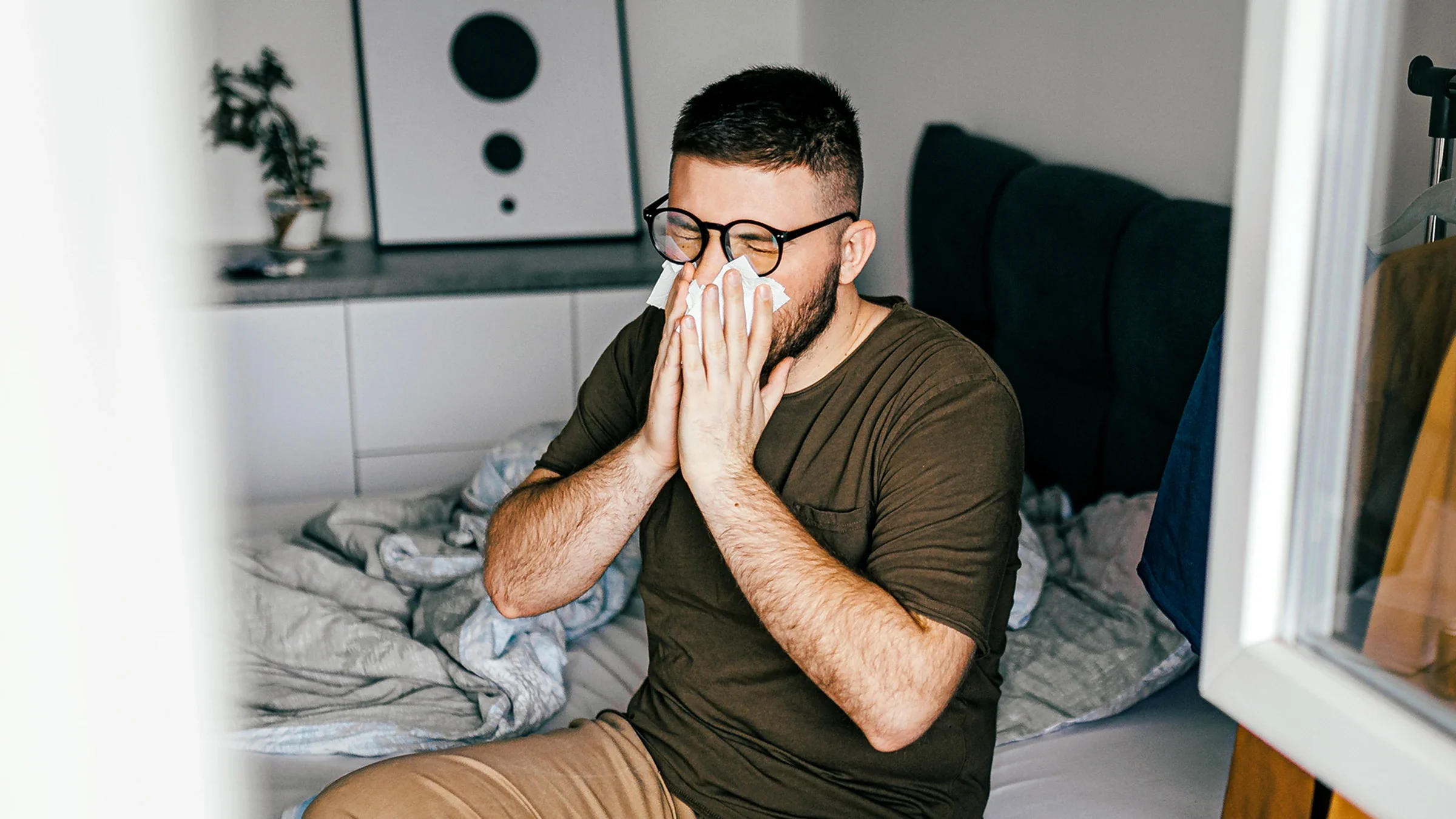 Man blowing his nose in bed
Eleganza/E+ via Getty Images