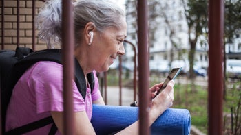 Ear: senior woman wearing ear buds 1476735514