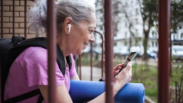 Ear: senior woman wearing ear buds 1476735514