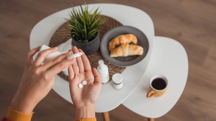 Aerial view of someone taking pills with their breakfast.