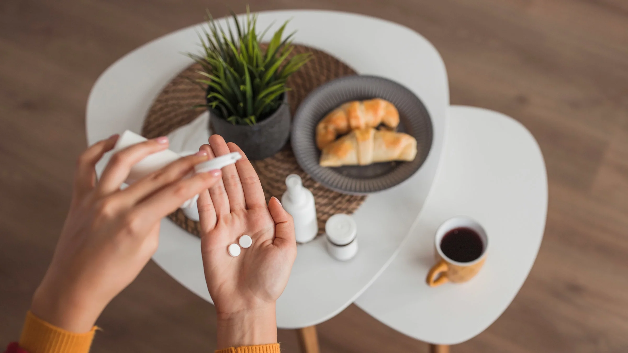 Aerial view of someone taking pills with their breakfast.