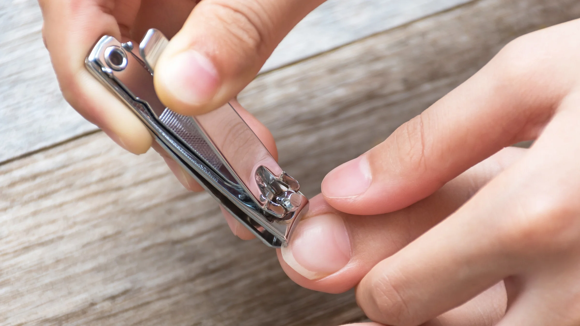 Close-up of a person clipping their big toenail.