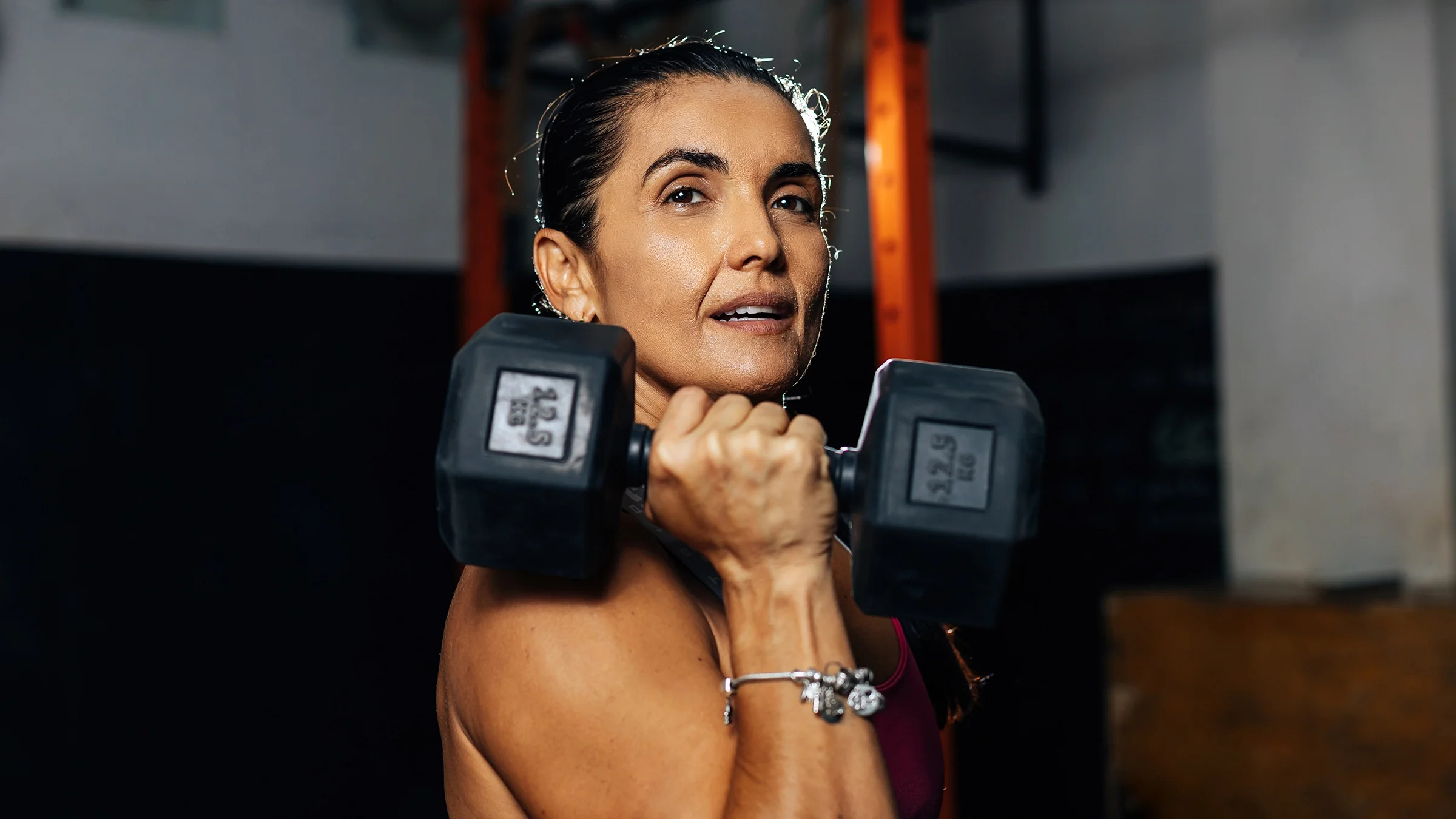 Portrait of woman doing a bicep curl at the gym.