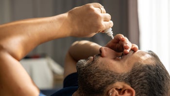 NSAIDS: man using eye drops 2179815993
