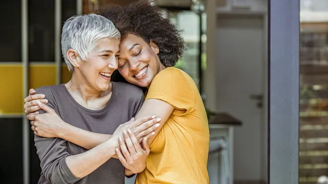 friends hugging smiling-1159638684