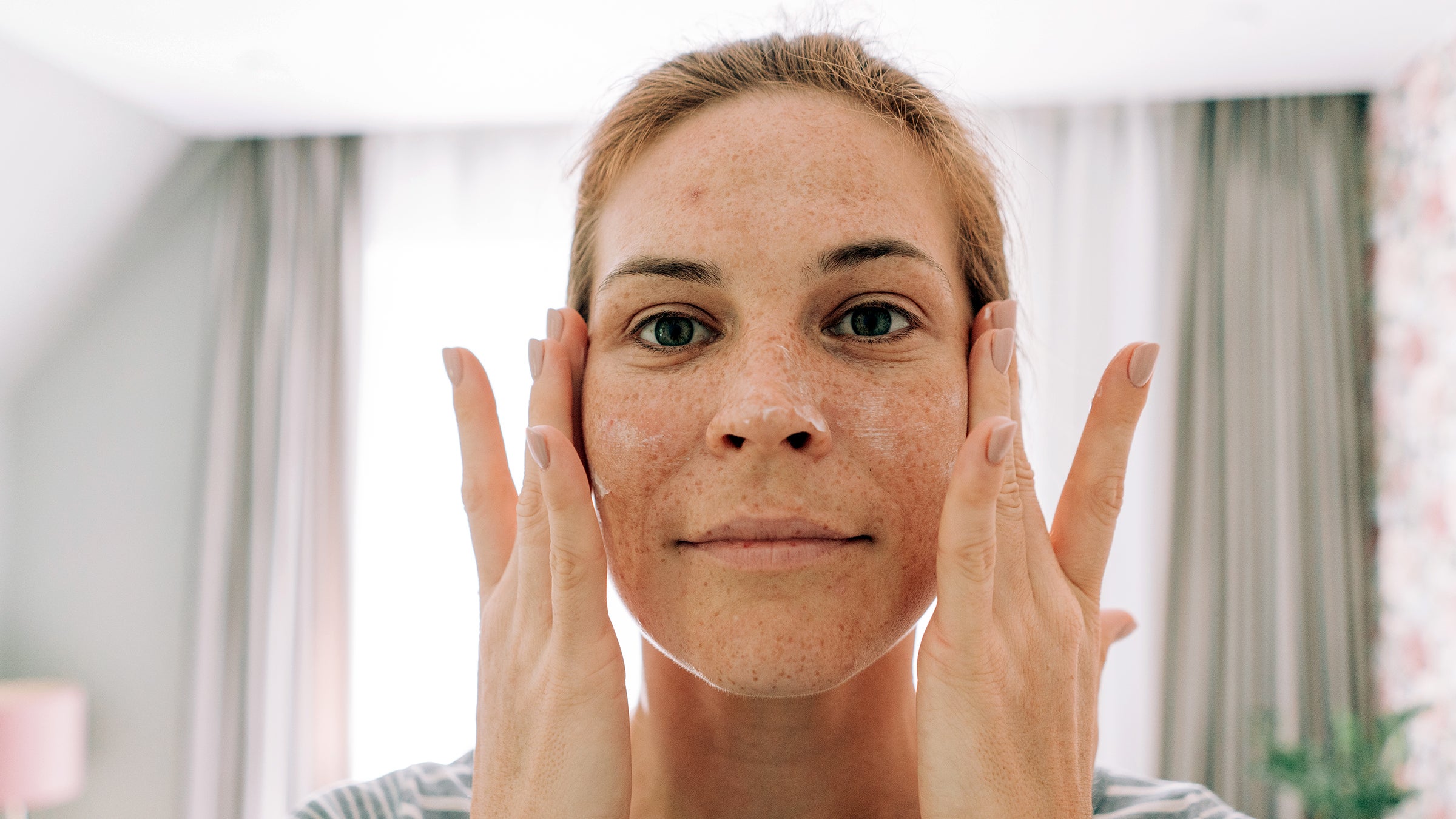 Dermatology: woman applying face cream 2172781951