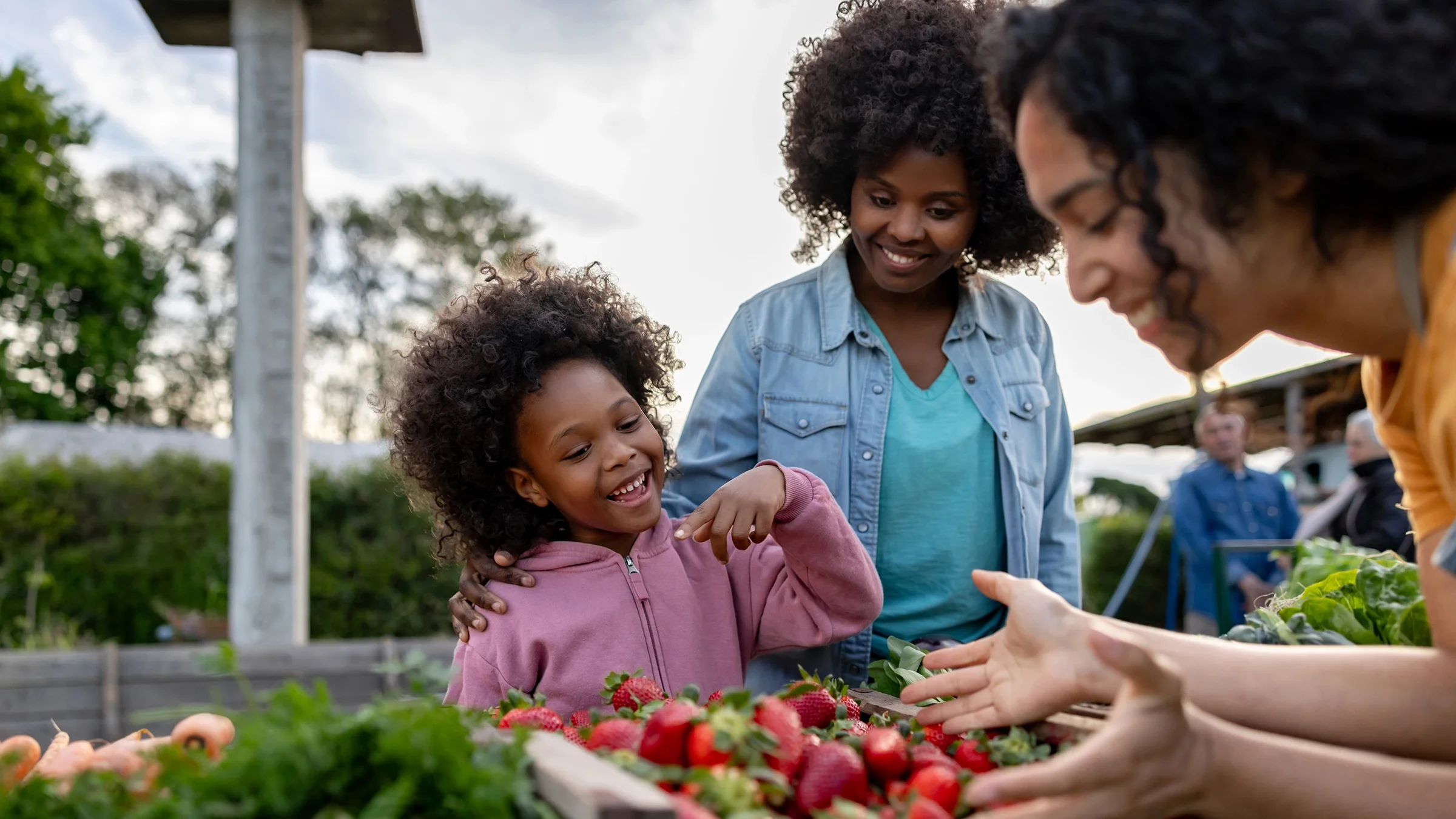 A mother and her young daughter are pictured shopping at a farmers market.
