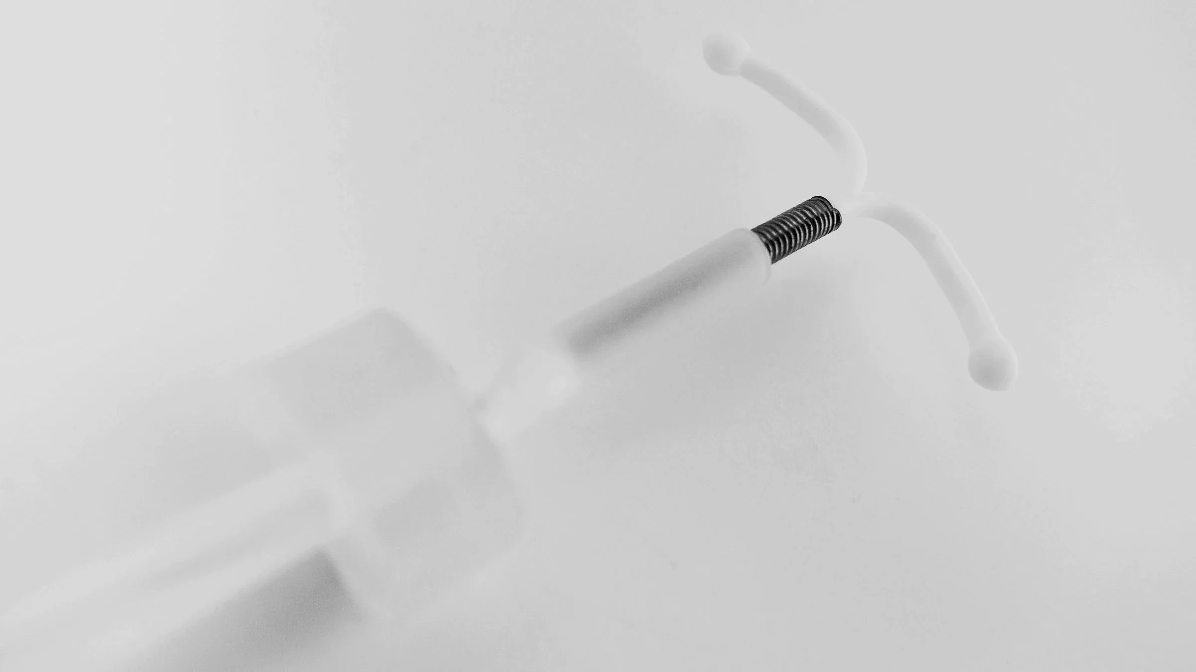 Black and white image of an IUD on a plain background.