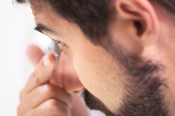 Close-up of a man putting in contact lenses.