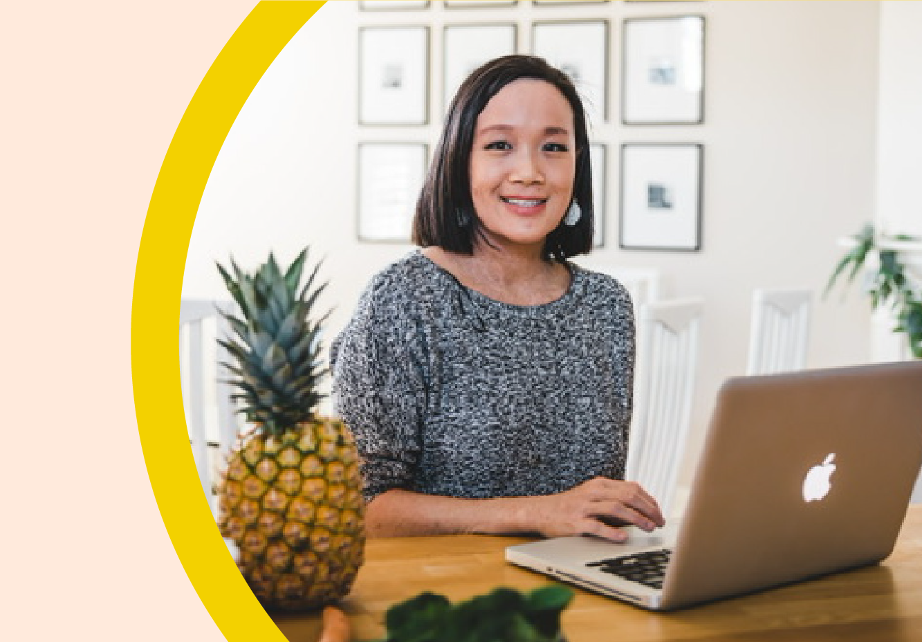 Image of Abby Tai working on her computer and smiling at the camera.