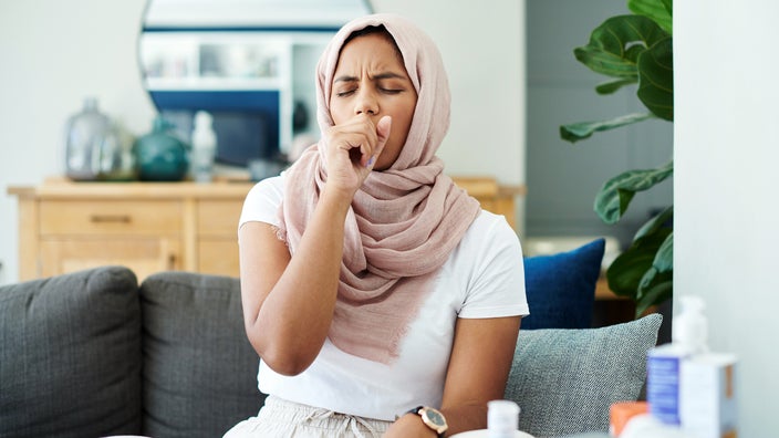 Woman with the hiccups and sitting on her sofa.