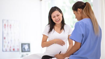 Health: conditions: urinary tract infection: pregnant woman doctor writing 1302891223