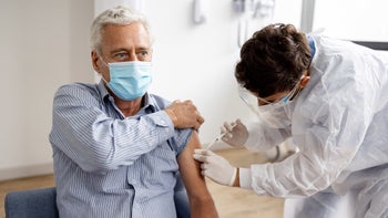 COVID-19: senior man receiving vaccine shot 1352251601
