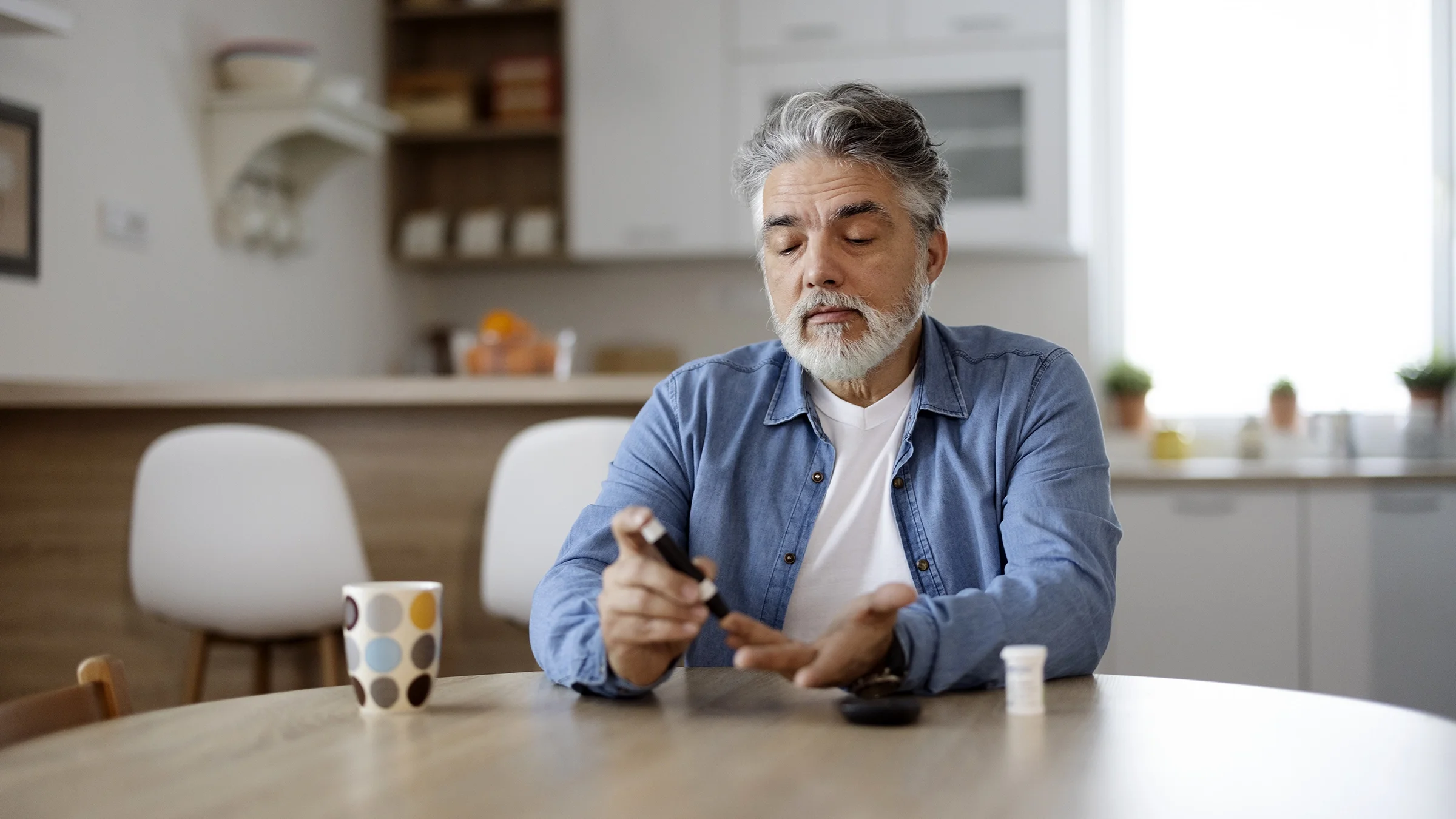 A man measures his blood sugar at home.