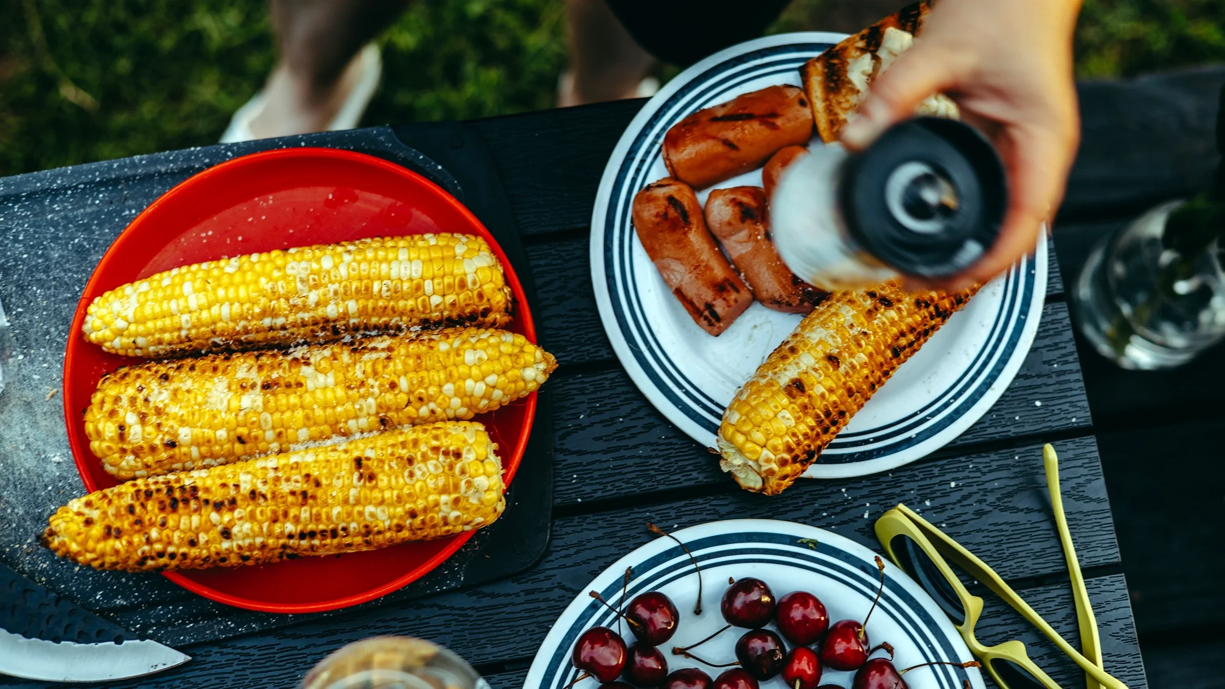 Grilled corn on a red plate.
