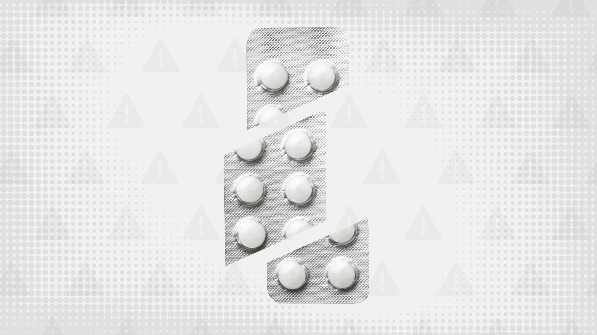 In the center of a light gray background with texture and warning sign pattern is a blister pack of round white pills cut into thirds. 
GoodRx Health