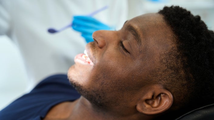 A man is seen smiling at the dentist’s office in a close-up.