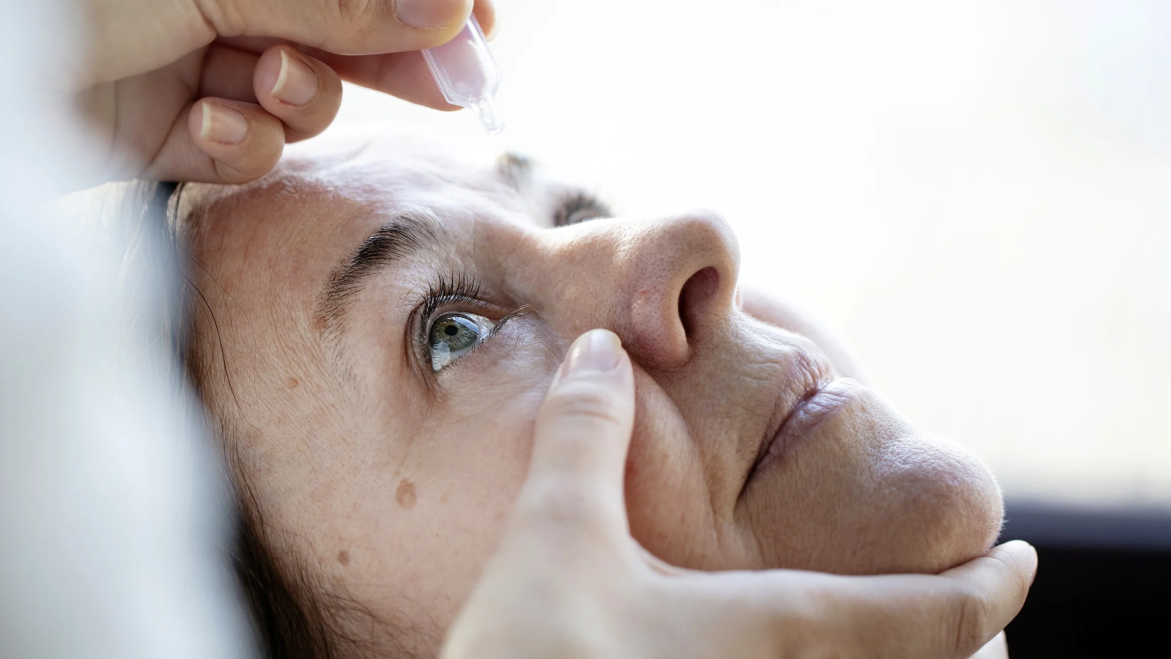Close-up of a woman getting eye drops.